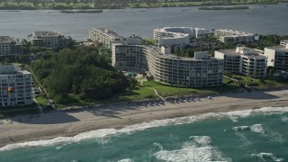 AX0032_065 - 5K aerial stock footage of flying by a condominium complex on the coast, Palm Beach, Florida