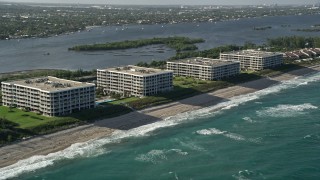 AX0032_068 - 5K aerial stock footage of flying by coastal condominium complexes, Palm Beach, Florida