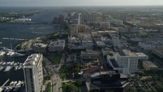 AX0032_085 - 5K aerial stock footage of panning across office buildings, revealing boats docked, West Palm Beach, Florida