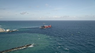 AX0032_110E - 5K aerial stock footage of approaching and orbiting a dredging ship near the coast, Palm Beach Shores, Florida