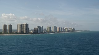 AX0032_115 - 5K stock footage aerial video of flying by coastal condominium complexes, Riviera Beach, Florida