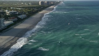 AX0032_130 - 5K aerial stock footage of flying by the beach, approaching kite surfer, Juno Beach, Florida