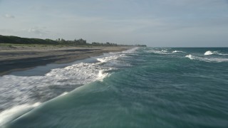 AX0032_149E - 5K aerial stock footage fly over Atlantic Ocean, revealing waves lapping the beach, Hobe Sound, Florida