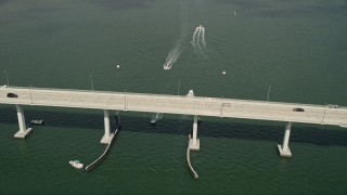 AX0033_007 - 5K aerial stock footage of following speedboats near a bridge in the Indian River, Stuart, Florida