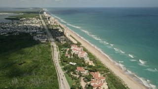 AX0033_010E - 5K aerial stock footage of condominium and apartment complexes by the beach, Jensen Beach, Florida