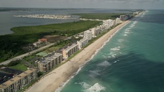 AX0033_012 - 5K aerial stock footage of beachside apartment buildings and blue ocean waters, Jensen Beach, Florida