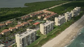 AX0033_018 - 5K aerial stock footage of following the beach blue waters toward vacation rentals, Jensen Beach, Florida