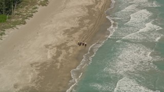 AX0033_030 - 5K aerial stock footage of orbiting away from horseback riders on the beach, Fort Pierce, Florida