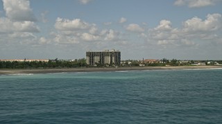 AX0033_039 - 5K aerial stock footage of flying by a beachfront apartment building, Fort Pierce, Florida