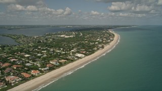 AX0033_055E - 5K aerial stock footage of following the beach by residential neighborhoods Vero Beach, Florida