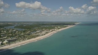 AX0033_062 - 5K aerial stock footage of flying by the beach and a coastal community, Vero Beach, Florida