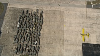 AX0033_081 - 5K aerial stock footage of tilting to helicopter bodies stored at Melbourne Regional Airport, Florida