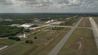 AX0033_082 - 5K aerial stock footage flyby a runway and hangar at Melbourne Regional Airport, Florida
