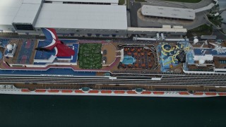 AX0034_019 - 5K aerial stock footage approach and tilt to a docked Carnival Cruise Ship, Port Canaveral, Florida