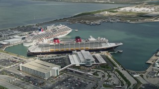 AX0034_020 - 5K aerial stock footage orbit Disney and Carnival Cruise Ships, Port Canaveral, Florida