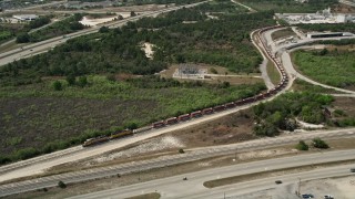 AX0034_028 - 5K aerial stock footage of approaching a stopped train, Cocoa, Florida