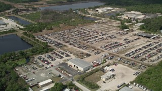 AX0034_030 - 5K aerial stock footage of approaching an auto salvage lot, Cocoa, Florida