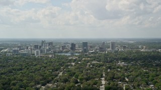 AX0034_083E - 5K aerial stock footage fly over trees toward Downtown Orlando, Florida