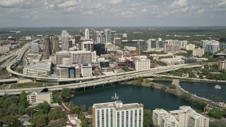 AX0034_092E - 5K aerial stock footage of orbiting Lake Lucerne, approach Downtown Orlando and the Expressway, Florida