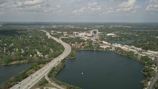 AX0034_097 - 5K aerial stock footage of approaching interstate beside a lake, Orlando, Florida