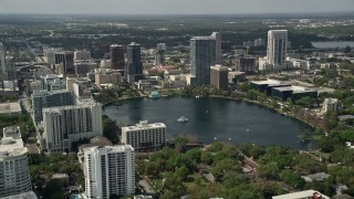 AX0034_103E - 5K aerial stock footage of passing by Lake Eola and Downtown Orlando, Florida