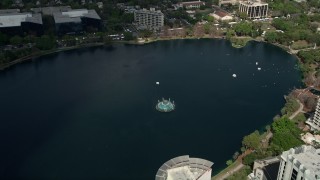 AX0034_112 - 5K aerial stock footage of approaching a fountain in the center of the lake, Downtown Orlando, Florida