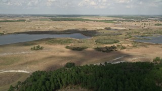 AX0035_088E - 5K aerial stock footage of approaching small lakes and farmland, Clermont, Florida