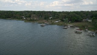 AX0035_129 - 5K aerial stock footage approach docks and lakefront homes by Lake Apopka, Ocoee, Florida