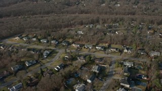 AX0065_0007E - 5K aerial stock footage fly over suburban homes and leafless trees in Plainview, Long Island, New York, winter