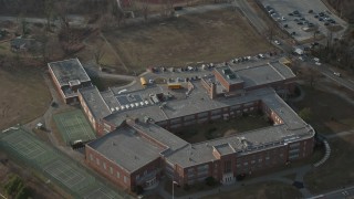 AX0065_0026 - 5K aerial stock footage tilt to bird's eye view of school busses at Great Neck North Middle School, Long Island, New York, winter