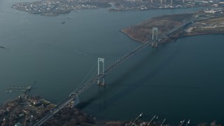 AX0065_0032E - 5K aerial stock footage of Bronx Whitestone Bridge spanning the East River, Long Island, New York, winter