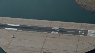 AX0065_0036 - 5K aerial stock footage of tracking a commercial jet landing on the runway at LaGuardia Airport, Queens, New York City, winter