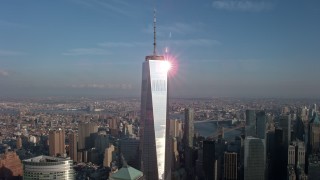 AX0065_0114 - 5K stock footage aerial video of an orbit of Freedom Tower with the sun reflecting off the building in Lower Manhattan, New York City, winter