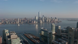 AX0065_0130E - 5K aerial stock footage of Lower Manhattan skyline seen from across the Hudson River, New York City, winter