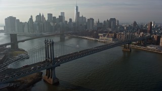 AX0065_0145 - 5K aerial stock footage flyby the Manhattan Bridge with a view of the Lower Manhattan skyline and the Brooklyn Bridge, New York City, winter