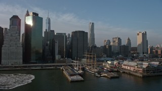 AX0065_0152E - 5K aerial stock footage pan across the Lower Manhattan skyline, revealing piers and historic ships, New York City, winter