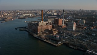 AX0065_0155 - 5K aerial stock footage of a riverfront power plant with smoke stacks in Brooklyn, New York City, winter