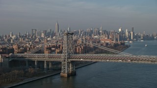AX0065_0157 - 5K aerial stock footage of light traffic on the Williamsburg Bridge, with Midtown Manhattan skyline in the background, New York City, winter