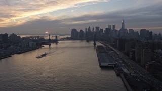 AX0065_0172E - 5K aerial stock footage view of Lower Manhattan skyline from Lower East Side public housing, Williamsburg Bridge, reveal Manhattan BridgeNYC, winter, sunset