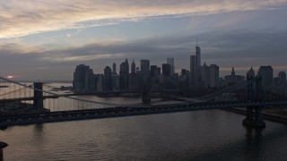 AX0065_0175E - 5K aerial stock footage fly over Manhattan Bridge, approach the Brooklyn Bridge and Lower Manhattan skyline, New York City, winter, twilight