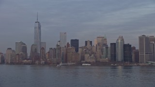 AX0065_0189E - 5K aerial stock footage approach the Lower Manhattan and WTC skyline from New York Harbor, New York City, winter, sunset