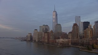 AX0065_0191E - 5K aerial stock footage fly low to approach to Freedom Tower and World Trade Center skyline, New York City, winter, sunset