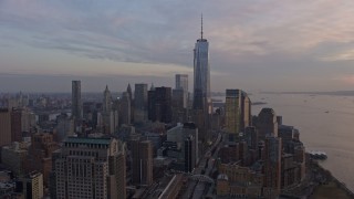 AX0065_0197E - 5K aerial stock footage of One World Trade Center towering over Lower Manhattan skyscrapers, New York City, winter, sunset