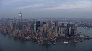 AX0065_0213E - 5K stock footage aerial video of Battery Park and Lower Manhattan skyscrapers in New York City, winter, twilight