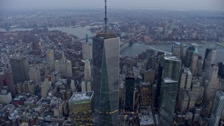 AX0065_0217E - 5K aerial stock footage of bird's eye of World Trade Center Memorial, tilt up and orbit Freedom Tower in Lower Manhattan, New York City, winter, twilight