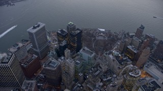 AX0065_0223E - 5K stock footage aerial video bird's eye view of downtown skyscrapers and Battery Park in Lower Manhattan, New York City, winter, twilight