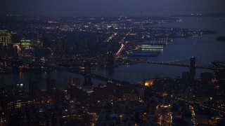 AX0065_0262E - 5K aerial stock footage of Manhattan and Brooklyn Bridges spanning East River, Brooklyn in the background, New York City, winter, twilight