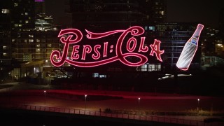 AX0065_0310E - 5K aerial stock footage fly low to approach and flyby the Pepsi Sign and riverfront apartment buildings in Queens, New York City, winter, night