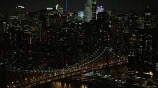 AX0065_0312E - 5K aerial stock footage tilt from the Queensboro Bridge to reveal Midtown Manhattan skyscrapers, New York City, winter, night