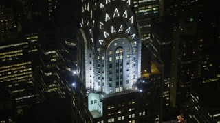 AX0065_0316E - 5K aerial stock footage orbit the side of the Chrysler Building in Midtown Manhattan, New York City, winter, night